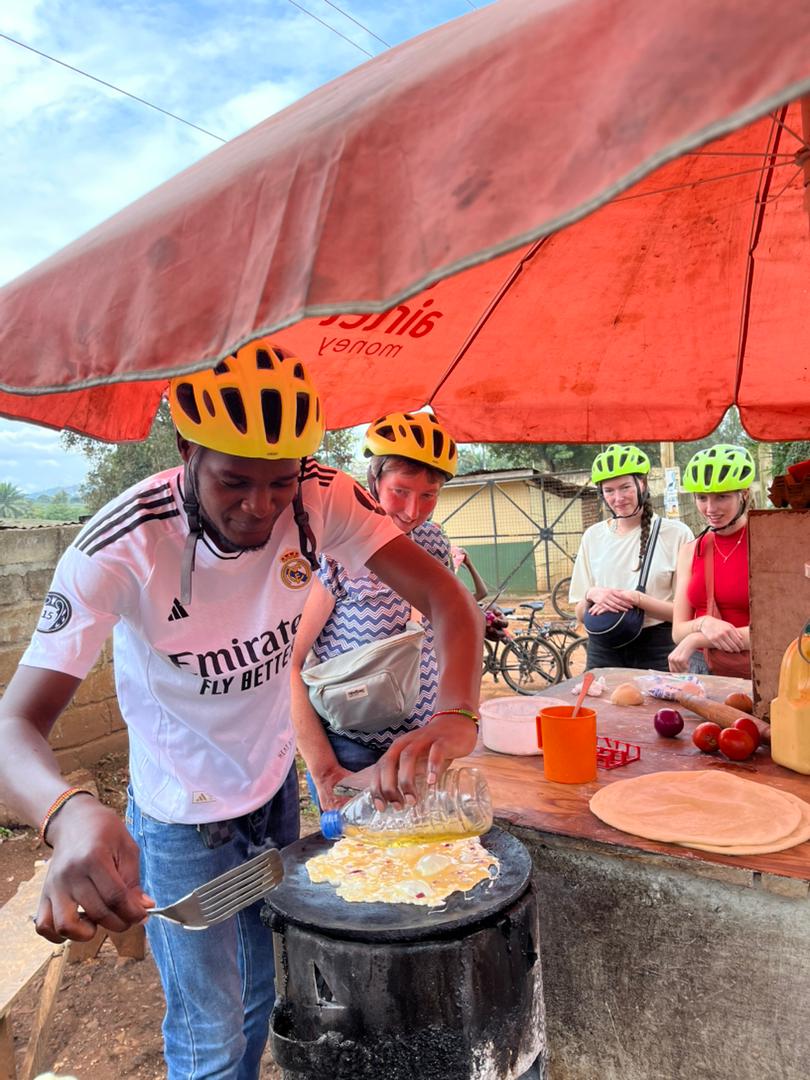 Group cultural cooking experience under traditional shelter
